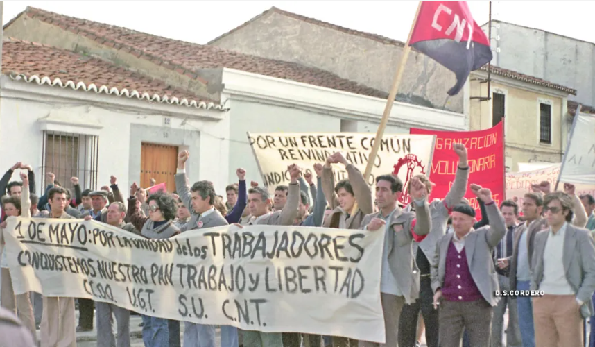 Luis Pablo es el chaval de la bandera cenetista, haciendo el saludo de manos enlazadas. Era muy friolero. Y ponía palos muy largos para las banderas.
